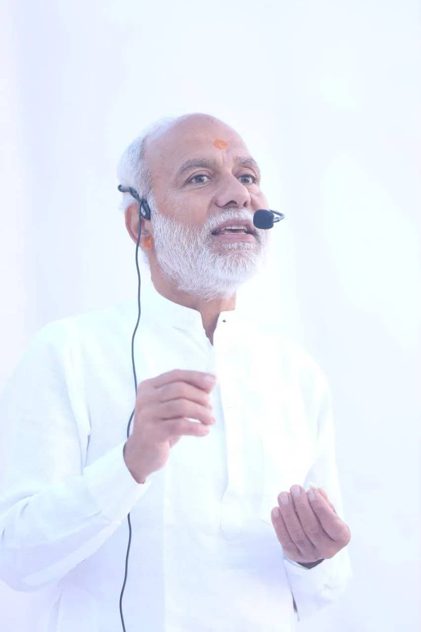 Pujya Param Aanand Ji speaking with a headset microphone